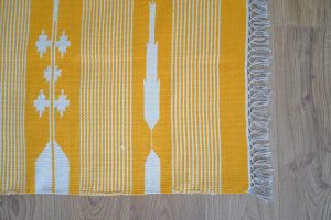 Detalle de alfombra moderna color amarillo y blanco